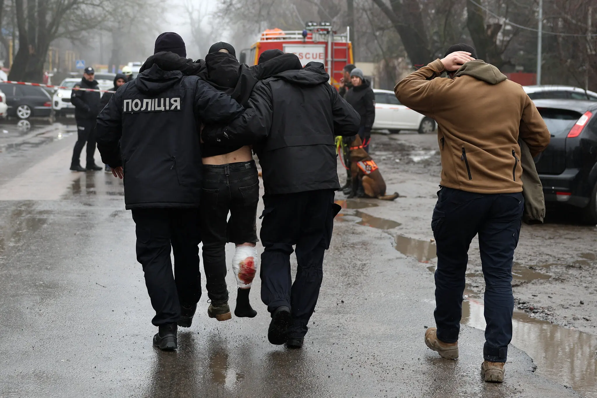 Співробітники екстреної допомоги допомагають постраждалому геть з місця події.